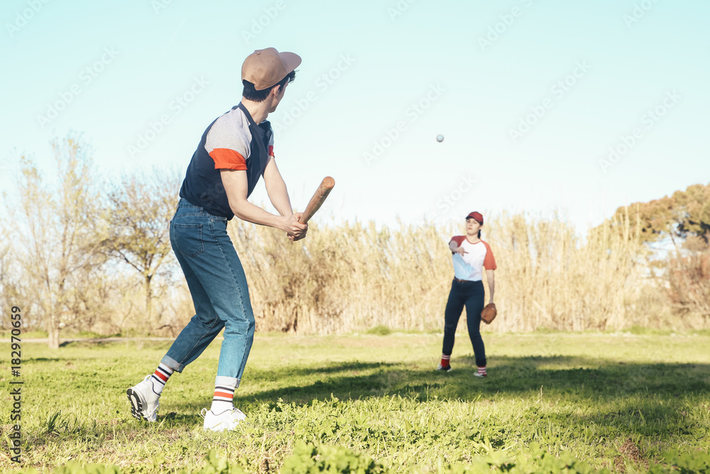 Young couple playing baseball in park
