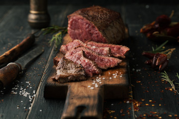 Fototapete Steakhouse Gegrilltes Steak mit Gewürzen Kräutern  © Belokoni Dmitri