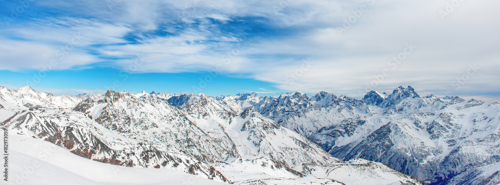 Obraz premium Mountains in snow. Panorama of winter landscape with peaks and blue sky