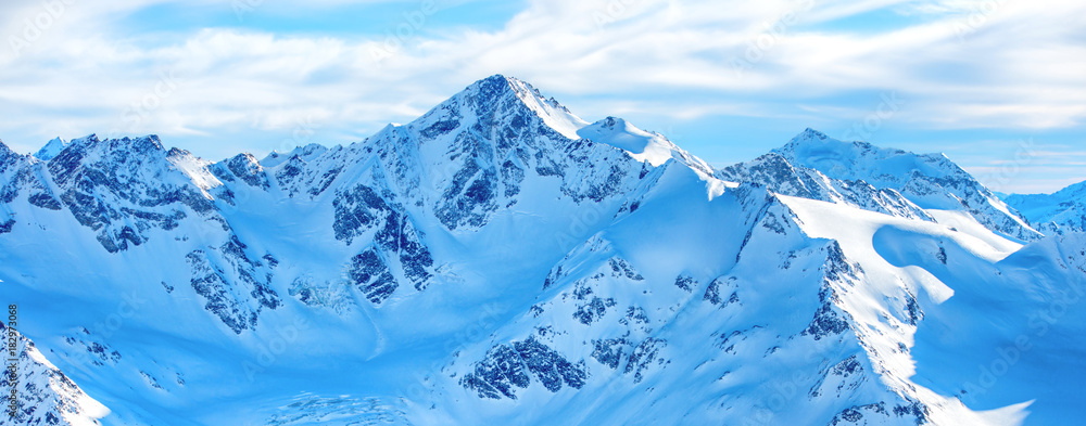 Naklejka premium Góry w śniegu. Panorama zima krajobraz z szczytami i niebieskim niebem