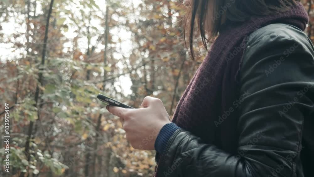 Close Up of Woman's Hands Using Smartphone In Autumn Park. Girl Walking In Forest In Fall, Lifestyle Concept Close Up of Woman's Hands Using Smartphone In Autumn Park. Girl Walking In Forest In Fall, Lifestyle Concept