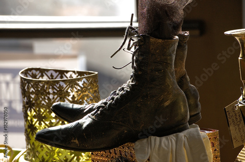 Vintage ladies boots lace up for sale in the window of an antique store