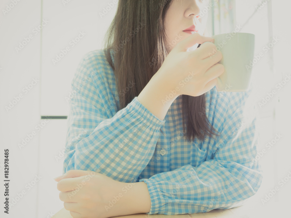 close up hand of asian girl 25s to 35s in blue pajamas at her bedroom during hold and drink coffee after her wake up close up hand of asian girl 25s to 35s in blue pajamas at her bedroom during hold and drink coffee after her wake up