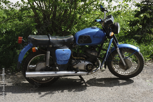 Vintage motorcycle standing in in the rays of sunlight. Side view