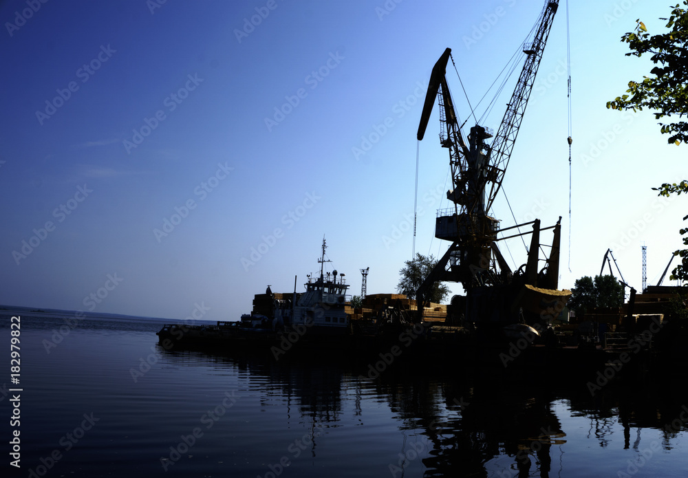 Monumental cranes at sunset.a ship in port Monumental cranes at sunset.a ship in port