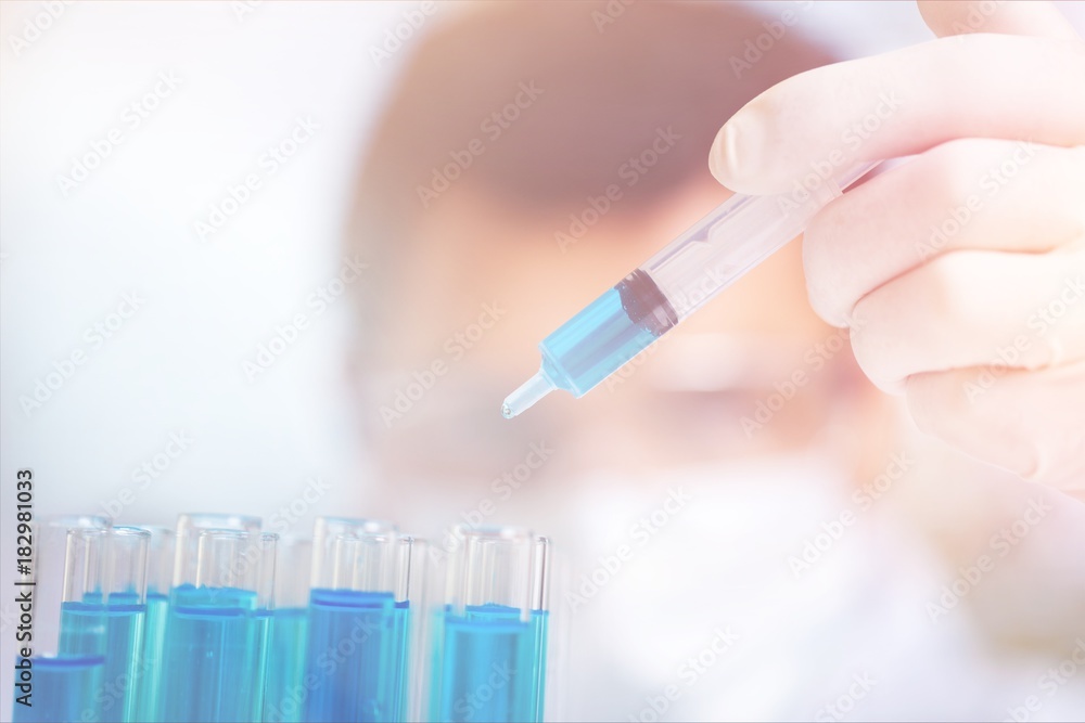 Hand holding syringe and vaccine.