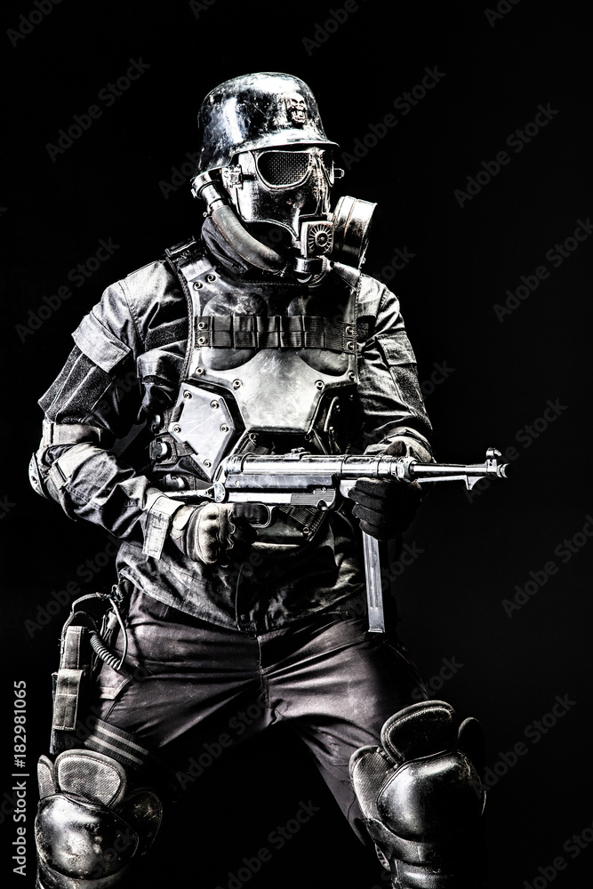 Futuristic  soldier gas mask and steel helmet with schmeisser handgun black background studio shot