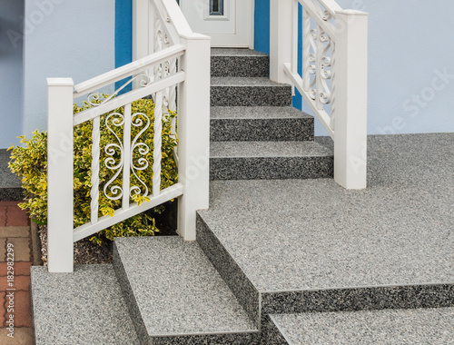 Moderne Außentreppe mit Beschichtung aus Steinteppich und Treppengeländer aus weiß lackiertem Aluminium - Modern outdoor staircase with stone carpet coating and white lacquered aluminium railing  photo