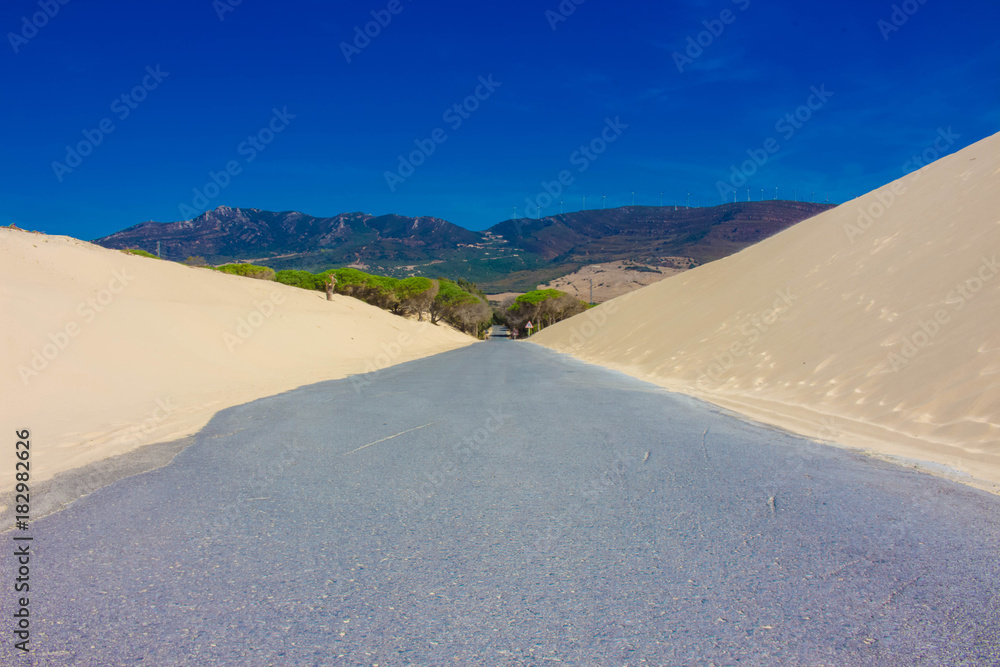Road. White ocean sand, dunes. Punta Paloma beach, Tarifa, Spain.