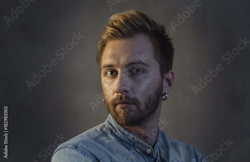 Portrait of bearded man face with stylish hairstyle on head and earring in ear © Valery Kazlitsinau