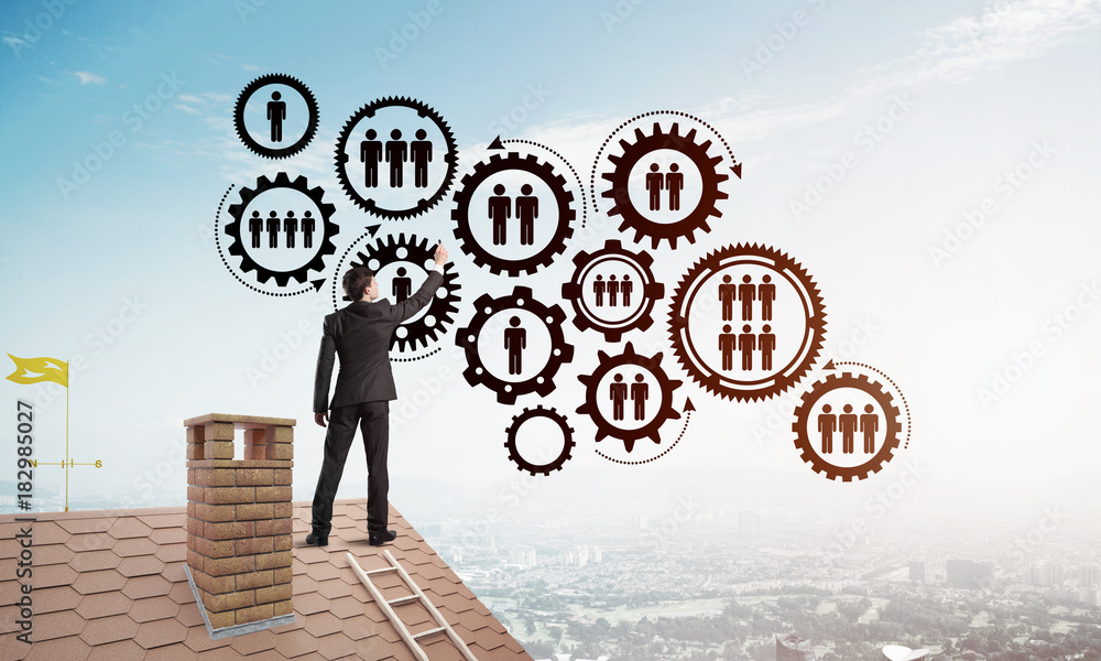 Businessman on house roof presenting teamwork and connection concept. Mixed media Businessman on house roof presenting teamwork and connection concept. Mixed media