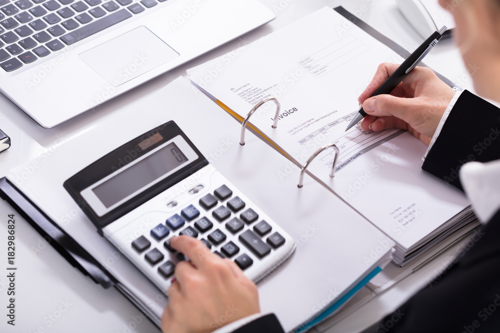 Businesswoman Hand Calculating Invoice Using Calculator Businesswoman Hand Calculating Invoice Using Calculator