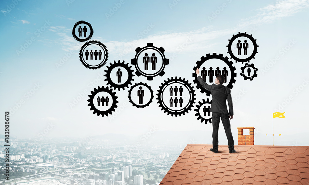 Businessman on house roof presenting teamwork and connection concept. Mixed media Businessman on house roof presenting teamwork and connection concept. Mixed media