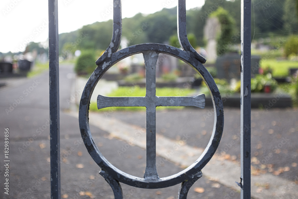 a cross on a cemetery entrance door a cross on a cemetery entrance door