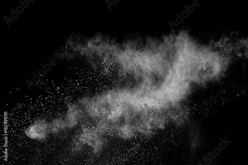 Freeze motion of white powder explosions isolated on black background. photo