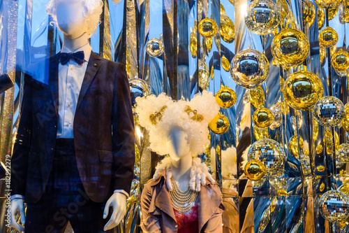 Male and female mannequins and different christmas decorations in a showcase