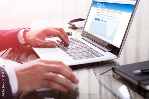 Businessperson Signing Into A Website On Laptop