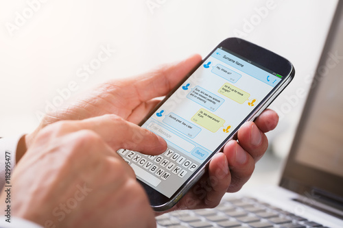 Businessperson Sending Text Message From Mobile Phone