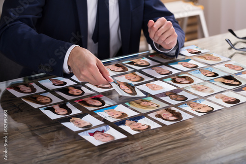 Businessperson Choosing Photograph Of Candidate