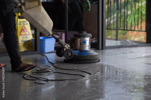 The people cleaning floor with machine.