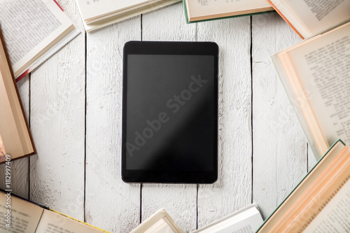 Black Ebook Reader with Many Paper Books photo