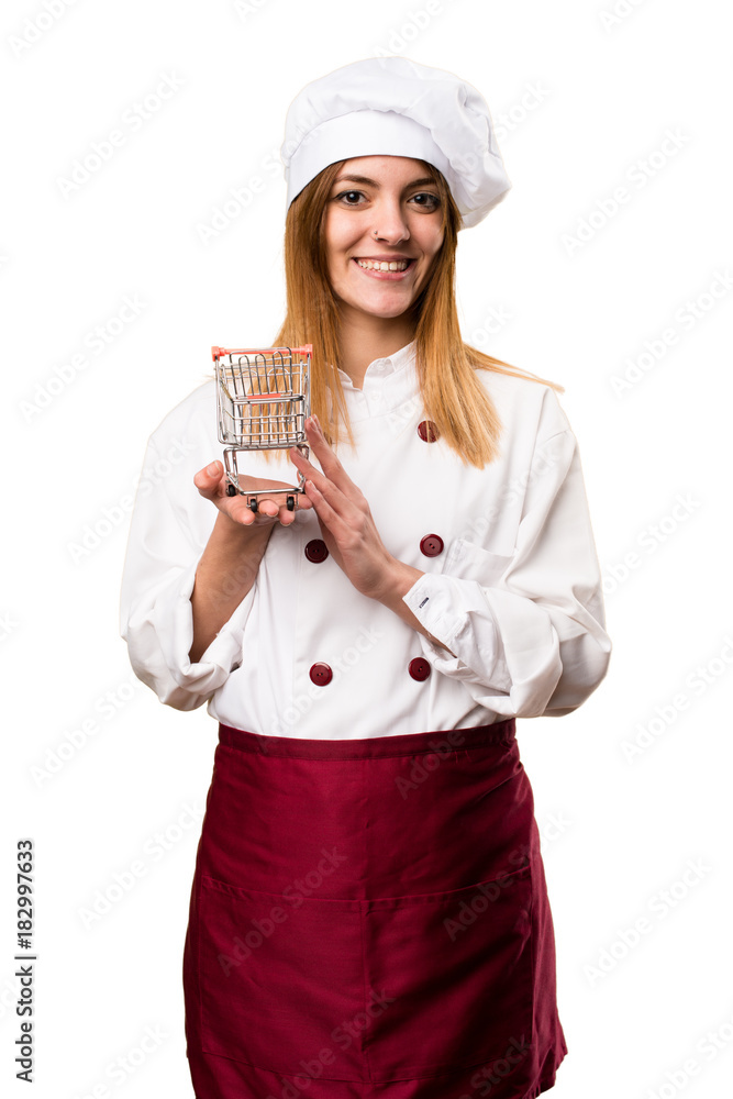 Happy Beautiful chef woman holding a supermarket cart toy Happy Beautiful chef woman holding a supermarket cart toy