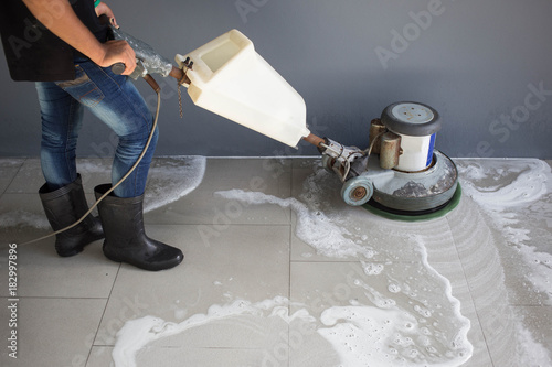 The people cleaning floor with machine.