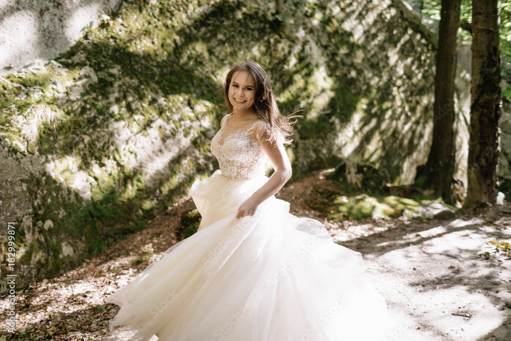 Beautiful stylish bride walking in the forest