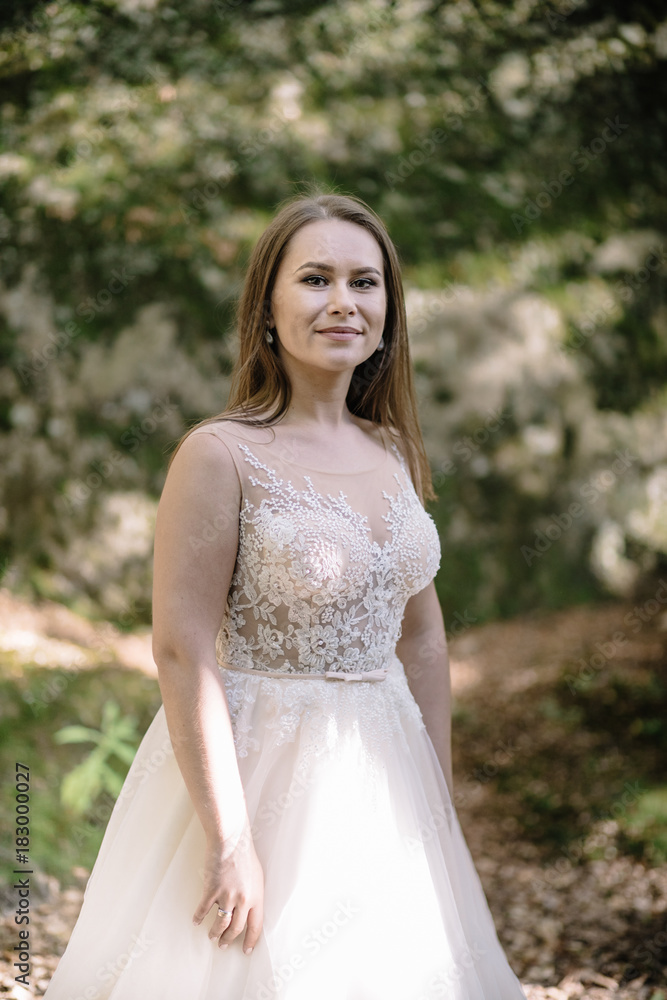 Beautiful stylish bride walking in the forest