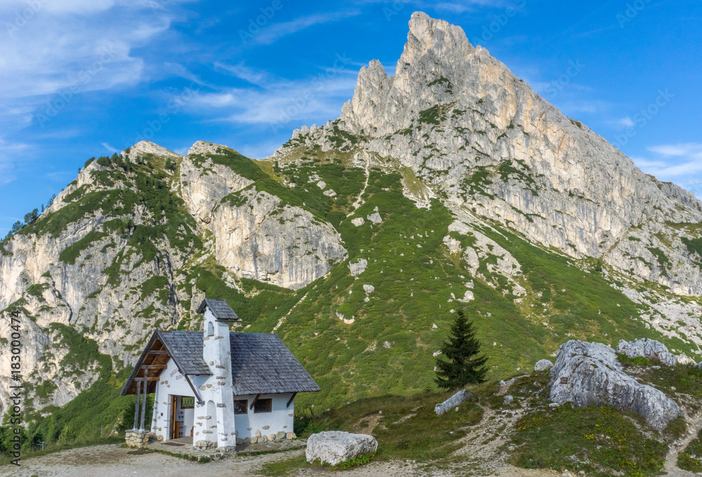 small white chapel and surrounding landscape on top of the Falzarego Pass in the Dolomites in Italy small white chapel and surrounding landscape on top of the Falzarego Pass in the Dolomites in Italy