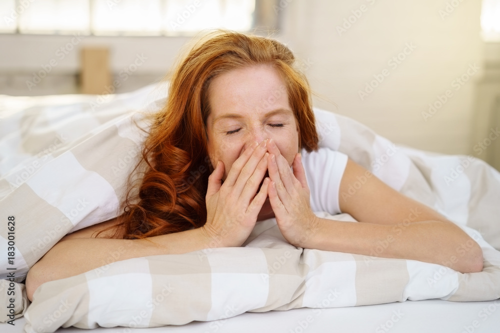 frau liegt im bett und gähnt frau liegt im bett und gähnt