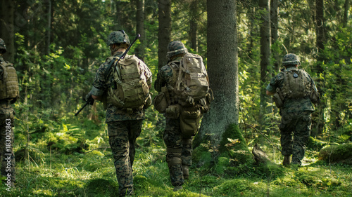Fotografía Squad of Five Fully Equipped Soldiers in Camouflage on a Reconnaissance Military Mission, Rifles in Firing Position