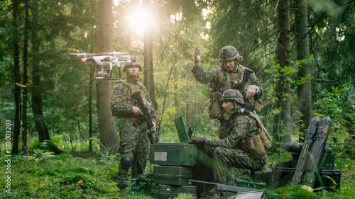 In the Military Staging Base Army Engineer and Soldiers Operate Military Grade Industrial Drone for their Reconnaisance/ Surveillance Mission/ Operation. Theater of Operation is in Forest Area.