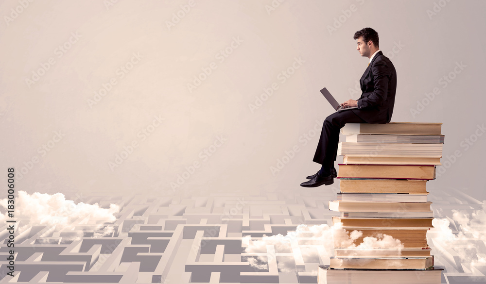Man with tablet sitting on books Man with tablet sitting on books