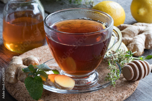 A cup of tea with ginger, lemon, herbs and honey