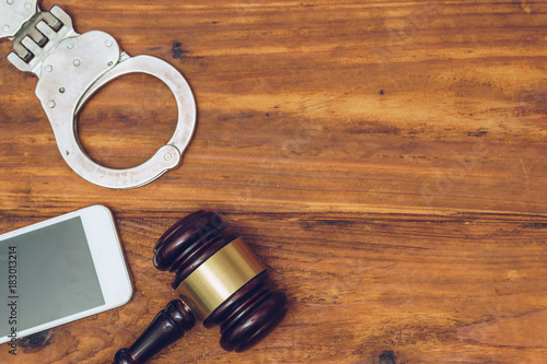 Judge gavel, handcuffs and smartphone, top view