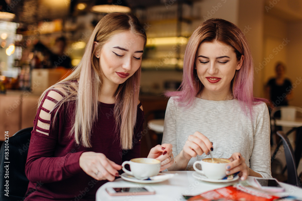 Two girls meat at coffee place and talk to each other, make conversation Two girls meat at coffee place and talk to each other, make conversation