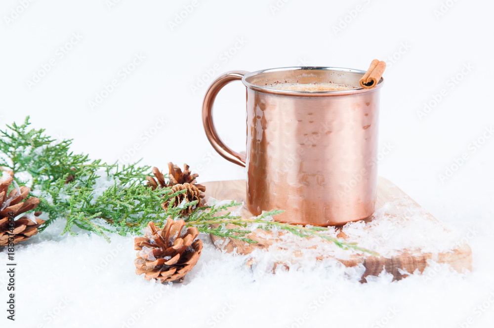 Eggnog in a copper mug with snow seasonal decorations Eggnog in a copper mug with snow seasonal decorations