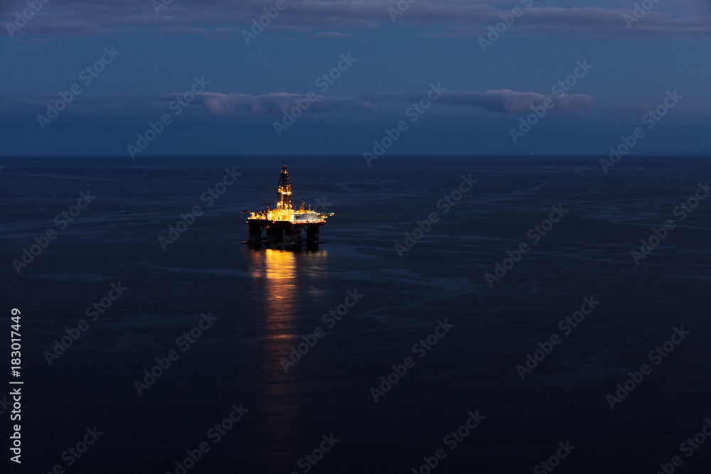 Offshore oil drilling rig on the south cost of Tenerife island on the North Atlantic Ocean. The sun has set revealing a beautiful light show