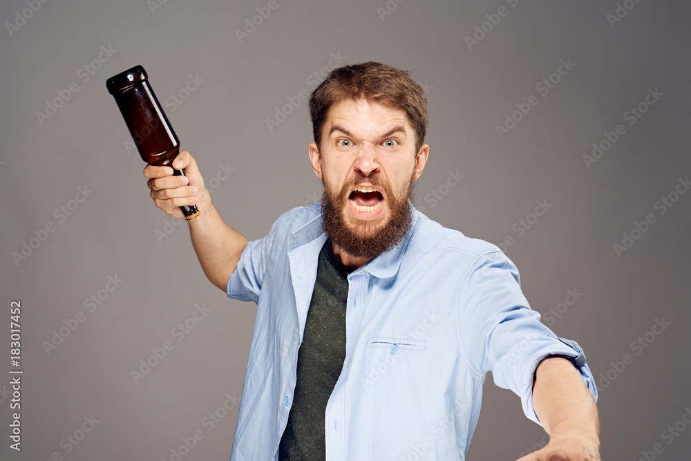 bearded man with bottle in hand, emotion, gray background bearded man with bottle in hand, emotion, gray background