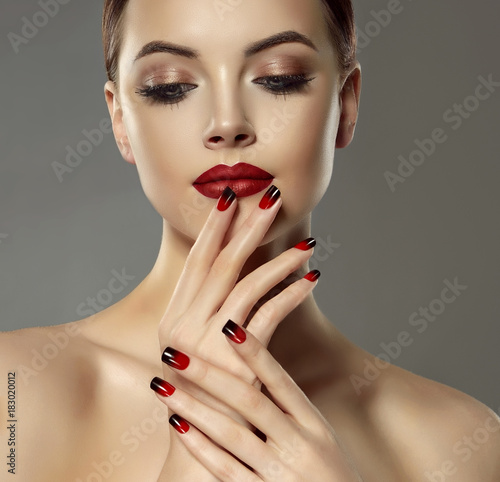 Beautiful model girl with red and black  french manicure on nails . Fashion luxury makeup . Beauty  and cosmetics .
