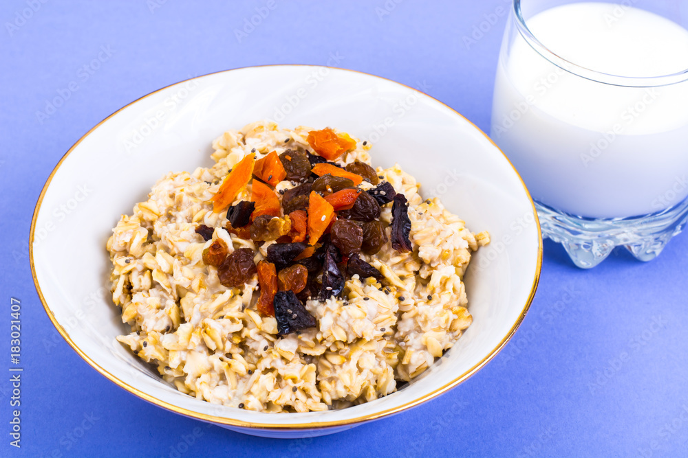 Healthy and diet food. Oatmeal with raisins, dried apricots, prunes and chia seeds on bright background Healthy and diet food. Oatmeal with raisins, dried apricots, prunes and chia seeds on bright background