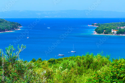 Wonderful romantic summer afternoon landscape panorama coastline Adriatic sea. Boats and yachts in harbor at magical clear transparent turquoise water. Cres island. Croatia. Europe.