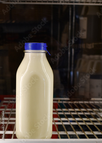 Isolated quart of white milk in glass container in grocery store refridgerator