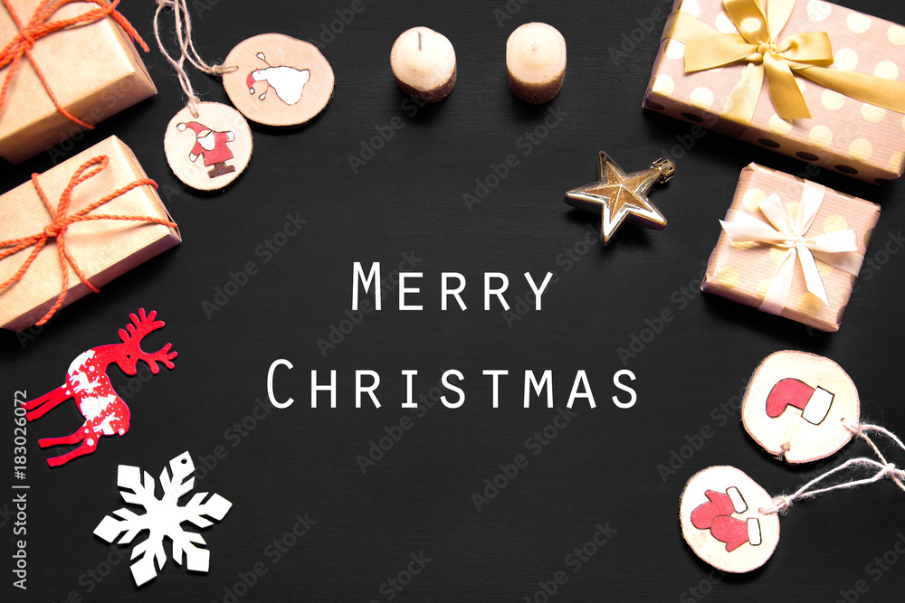 New year's background on a black desk decorated with toys, presents, Santa Claus, snowman. Bright colored background symbolizes the new year celebration. Great useful template to wright words down.
