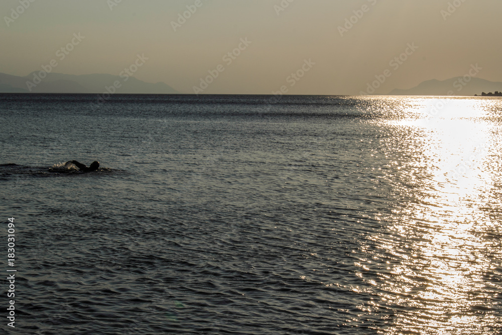 swimmer in the sea at sunset swimmer in the sea at sunset