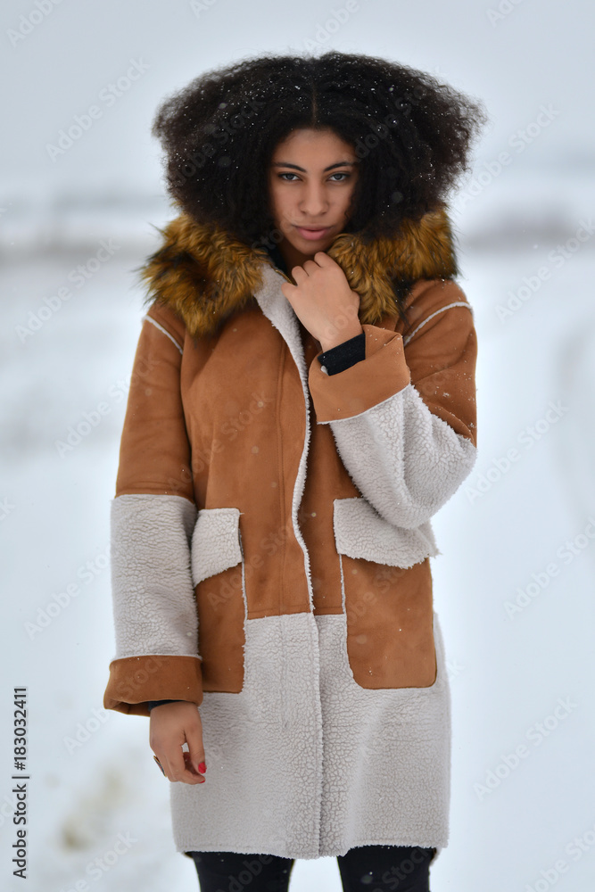Femme afro-américaine dans les vêtements d'hiver sur fond d'hiver. Stock  Photo | Adobe Stock