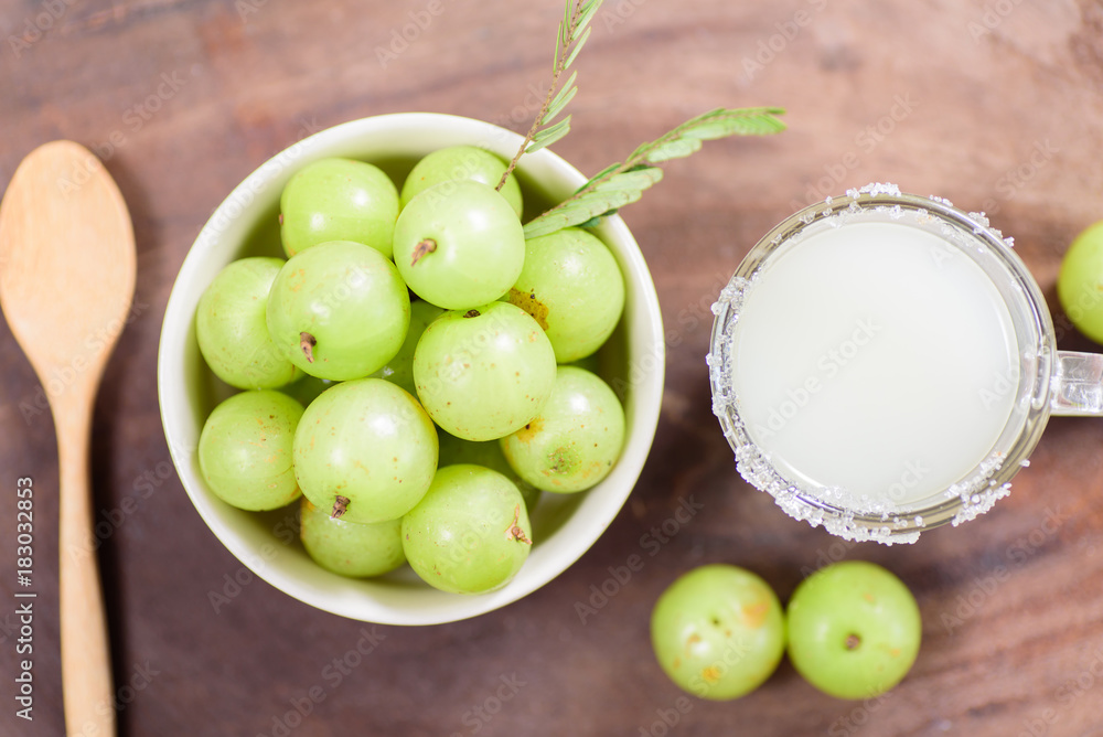 Top view of Indian gooseberry fruit and juice on wooden background,healthy food Top view of Indian gooseberry fruit and juice on wooden background,healthy food