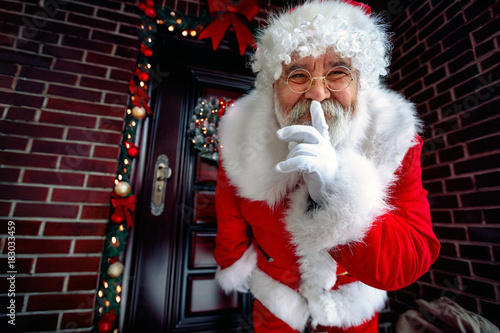 Portrait of Happy Santa Claus with finger on lips