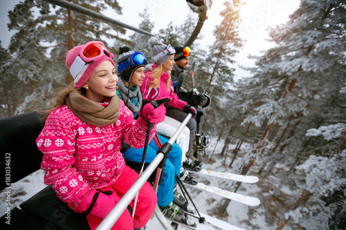 Skiing, ski lift, winter - girl skiers on ski lift at mountain